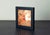 This artwork depicts a face emerging amid a flurry of white doves, capturing a moment of joy and liberation. The warm,...