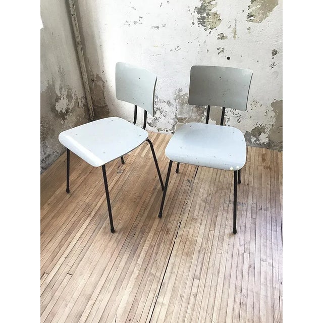 This is a pair of vintage bauhaus style chair with black metal structure and gray patinated wood seat, by the belgian...