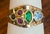 Modern 14 karat yellow gold ring with faceted stones in emerald, ruby, topaz, and sapphire. Stamped with maker's mark, 14K...