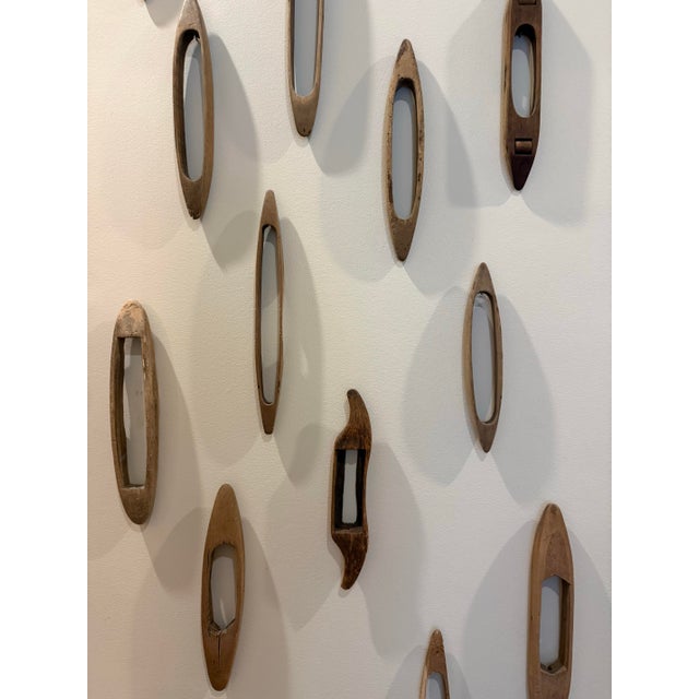This curated collection of vintage wooden weaving shuttles celebrates the beauty of traditional textile craftsmanship...