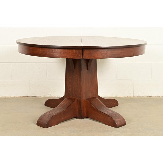 An outstanding antique Mission or Arts & Crafts period quarter sawn oak split pedestal extension dining table In the...