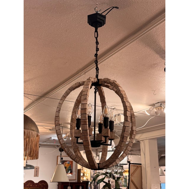 Design Plus Gallery presents a Wooden Block Orb Chandelier with a Black Metal Frame from Anthem. Intersecting wood block...