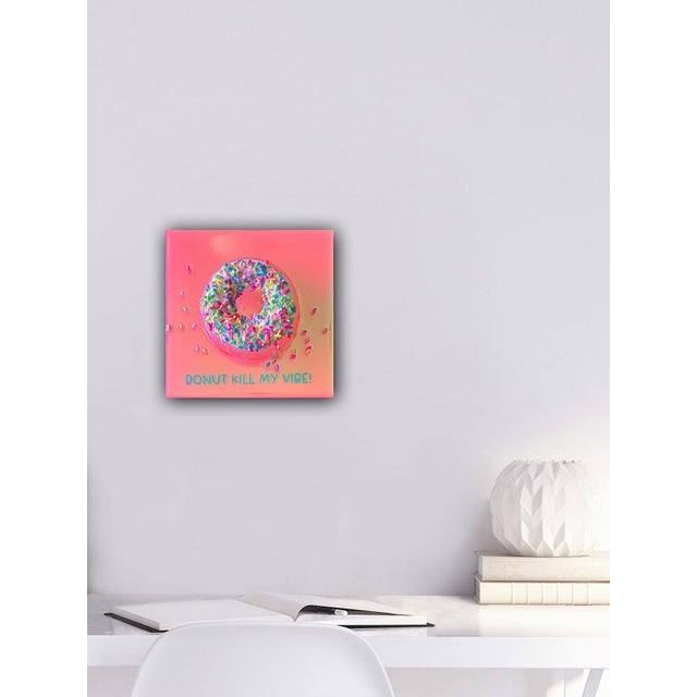 This mixed media piece features a vibrantly colored donut, adorned with a playful array of multicolored sprinkles, set...