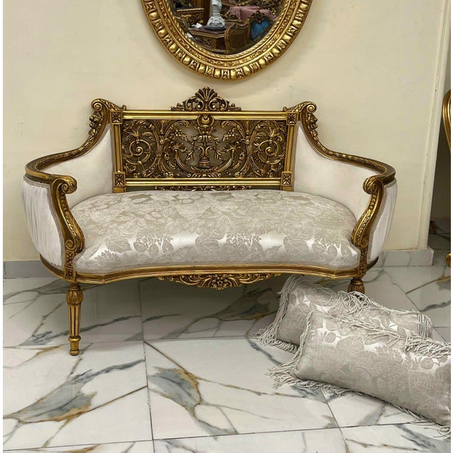 Elegant French Rococo sofa upholstered in luxurious white and beige damask, featuring exquisite hand-carved details and a...