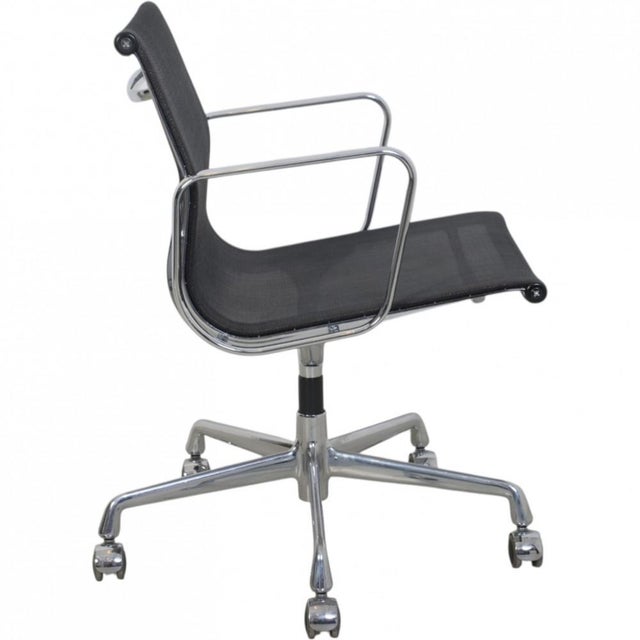 Charles Eames EA-117 office chair upholstered in black mesh, with chrome armrests and frame. The chair is from 1997 and...