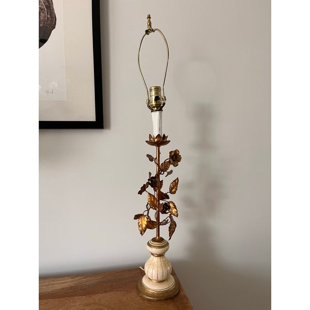 This vintage table Italian Regency table lamp features a delicate, hand-painted, tiered, ivory base with gold floral and...