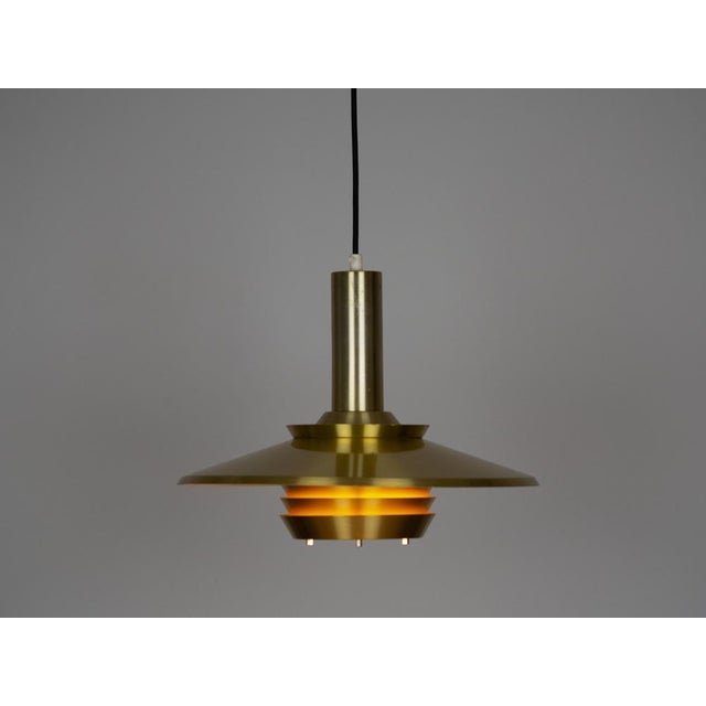 A Danish aluminum lamp from the 1960s. The lamp is reminiscent of Carl Thore's designs. The lamp's form is based on the...