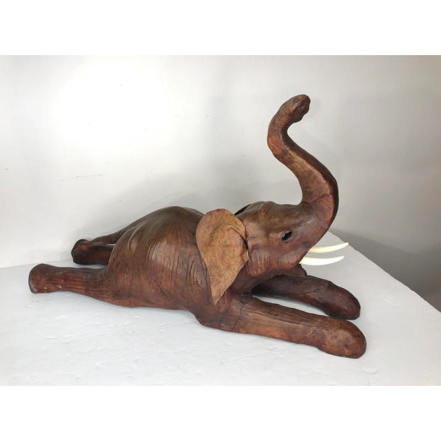 Vintage Leather Covered Elephant Figure with Glass Eyes. Elephant is in a prone position with legs outstretched and head...
