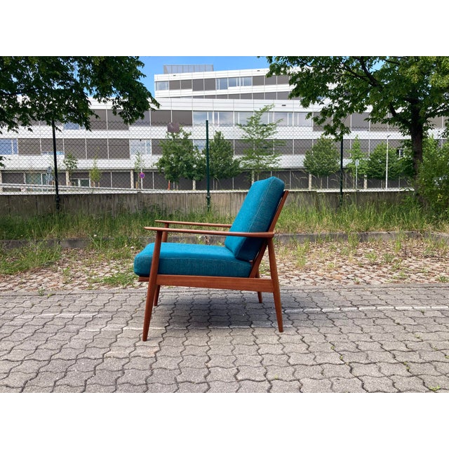 This Wilhelm Knoll Antimott easy chair features its original petrol-blue upholstery, innerspring seating, and an oiled...