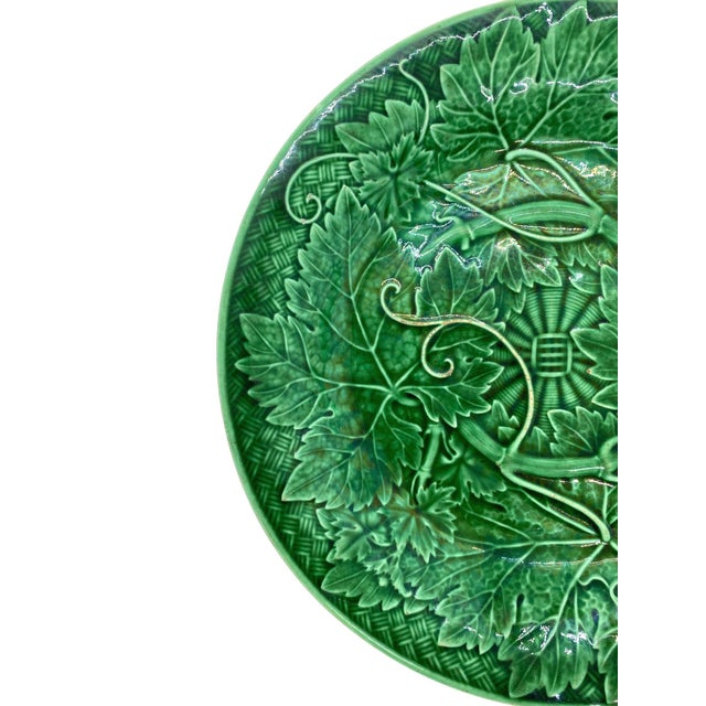 Wedgwood Majolica green glazed plate, with relief-molded grape leaves and vines, raised on a basketweave ground, the...