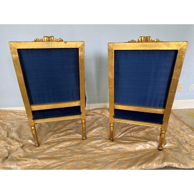 A magnificent pair of French Louis XVI style open-arm fauteuils boasting an exceptionally regal color palette. The linear,...
