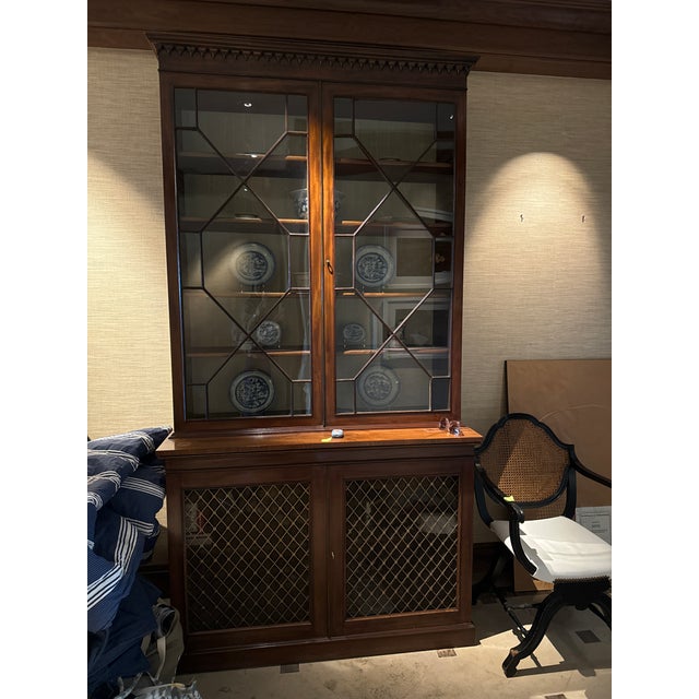 Elegant antique mahogany two-piece display cabinet with handsome architectural detailing and beautifully patterned...