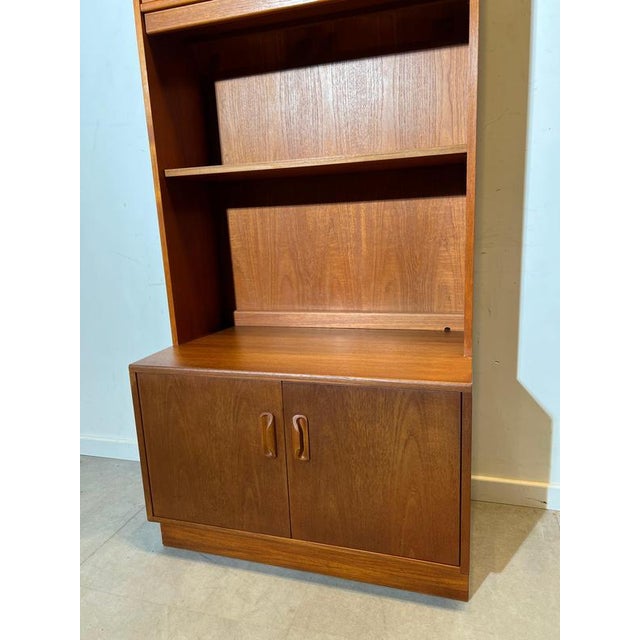 Elegant mid-century modern teak cabinet combining a display vitrine and storage unit in one harmonious piece. The upper...