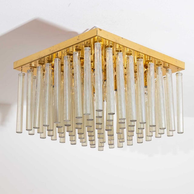 Ceiling chandelier with Tondo-shaped glass rods and square base plate in brass. This piece is attributed to the mentioned...