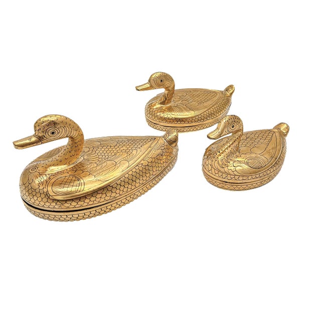 This set of three large graduated Burmese lacquerware trinket boxes takes the form of swimming ducks, each covered in gold...