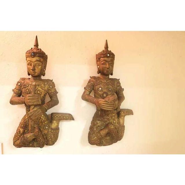 19th c. pair of elegant Large Siamese gilt carved teakwood figures one a musician holding a flute and one dancer holding a...