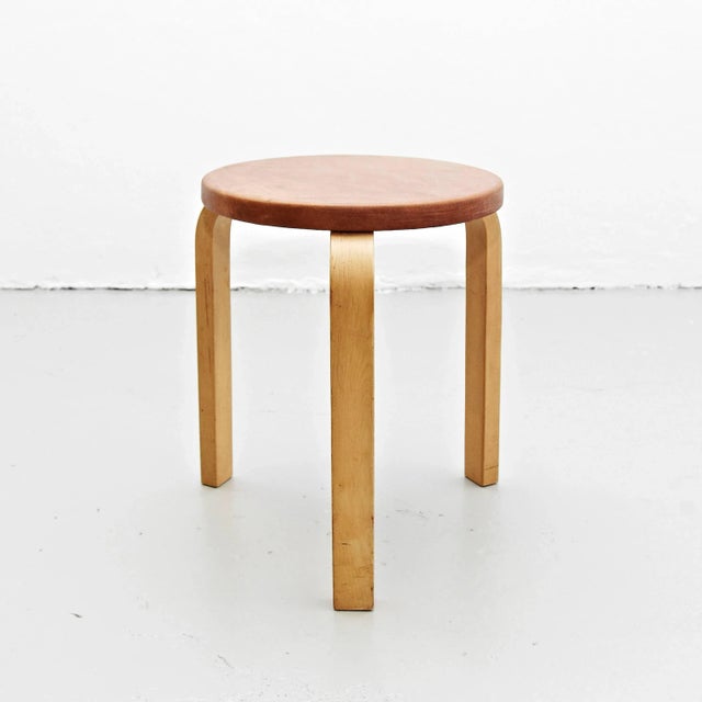 This stool from the 1960s is made of wood with a new brown leather seat.