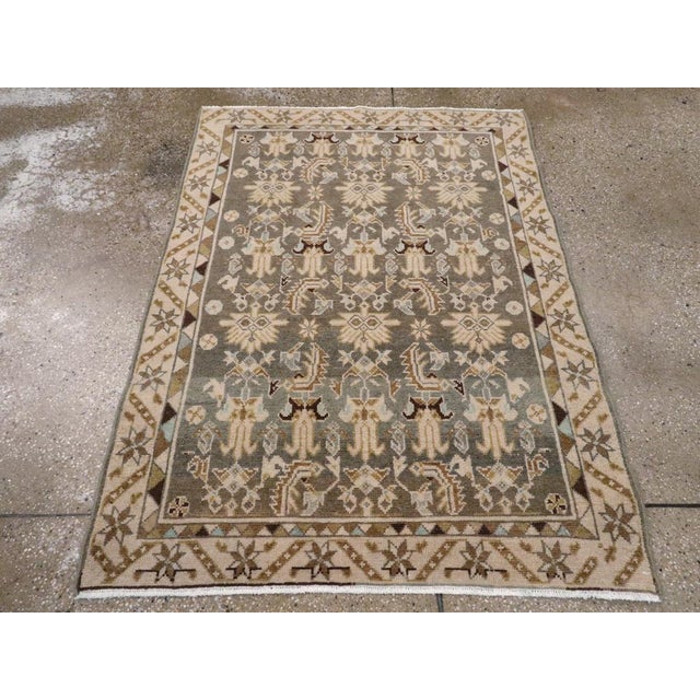 This mid-20th-century Persian Malayer rug presents a finely organized allover floral composition across a muted blue-grey...