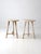 This pair of vintage pedestal side tables features softly distressed cream paint, round tops, and turned spindle legs...