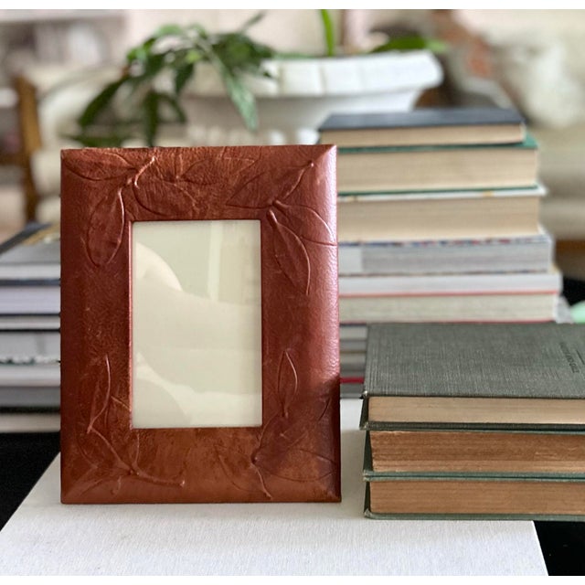 Handcrafted vintage picture frame wrapped in richly textured genuine leather and embossed with an elegant leaf motif. The...