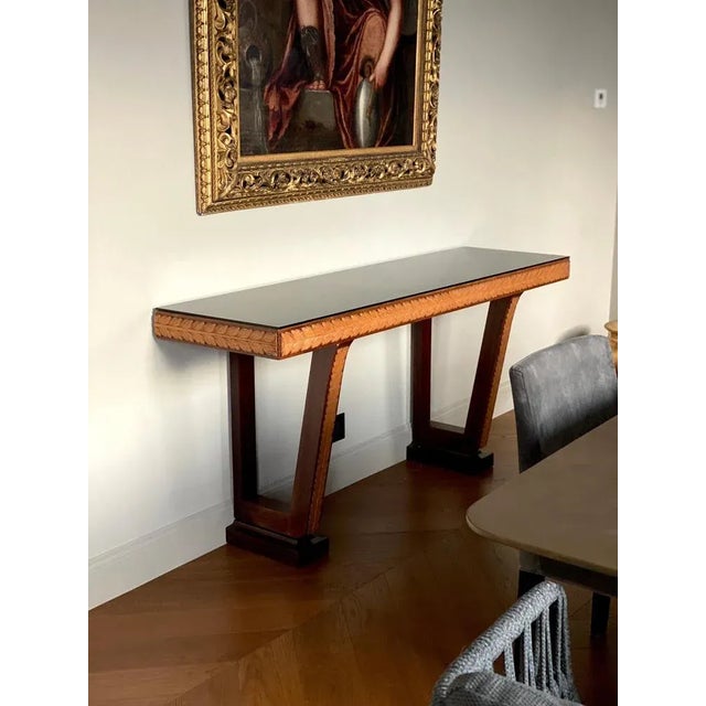 Elegant and rare Italian designed console table handcrafted finely carved in exotic woods and black glass top. Beautifully...