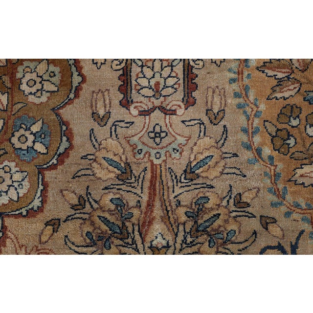 An early 20th century Persian Kirman rugs, the camel field with a loosely defined lattice of pendants and flowering vine...