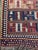 This vibrant vintage Ghashghai Kilim rug features bold horizontal tribal bands in an array of warm earth tones, rich reds,...