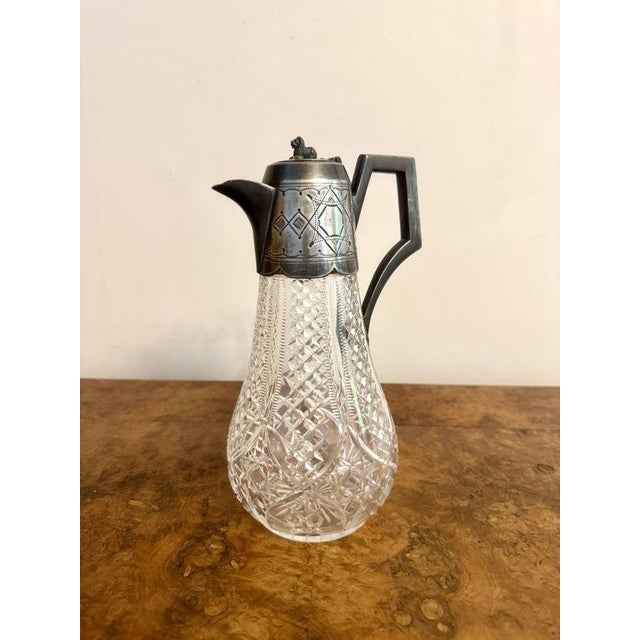 Quality antique Edwardian claret jug, having a quality antique Edwardian claret jug with a cut glass shaped body, with a...
