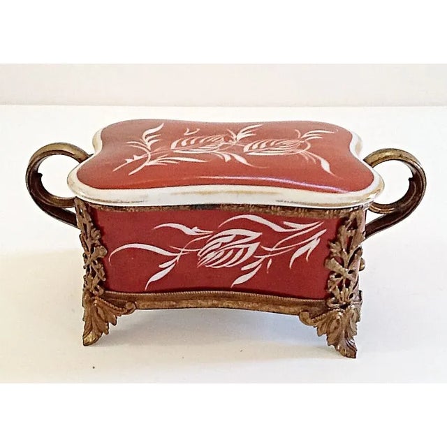 A sweet little French porcelain box with ormolu feet and base. It has a beautiful wheat design in white on a rich rose...