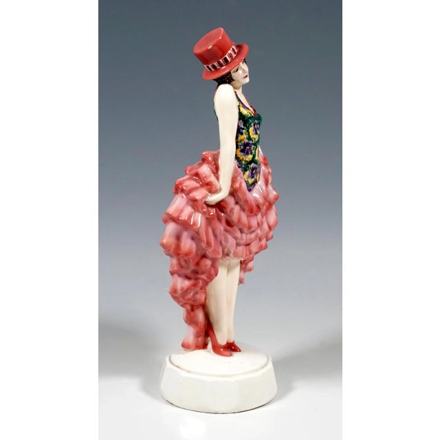 Rare goldscheider figure of the 1920s: the standing dancer wears a pink cylinder hat on her short brown locks. The flower-...