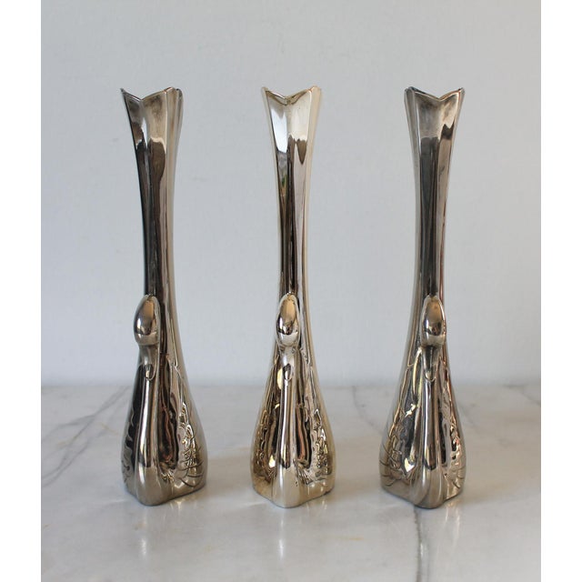 Set of three vintage silver-tone swan bud vase with an elongated fluted trumpet neck and detailed wing accents. One is...