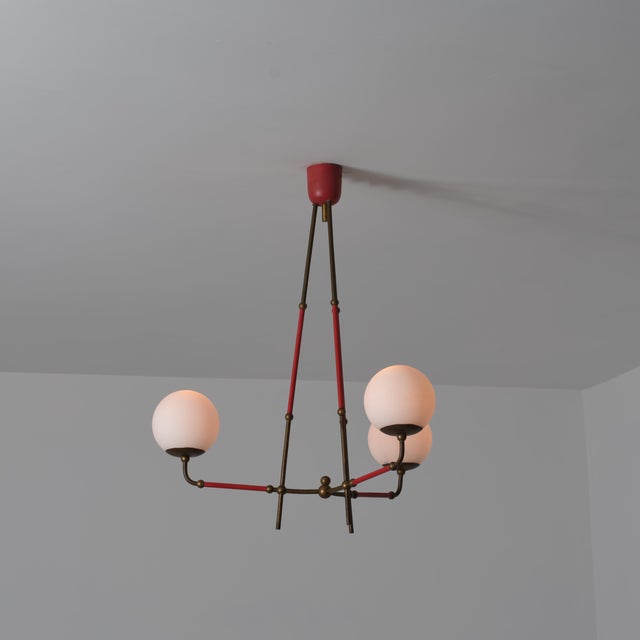 Italian mid-century pendant chandelier from the 1950s, characterized by a light and geometric structure that combines...