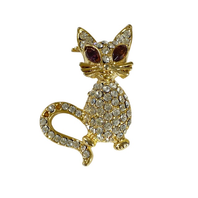 This vintage cat brooch is truly exceptional, featuring clear pave rhinestones, gold toned costume jewelry, and exquisite...