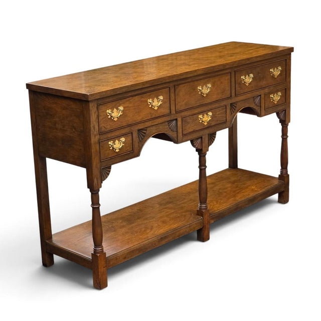 Exceptional Baker Furniture Georgian-style carved oak Welsh dresser, dating to the late 20th century. This impressive two-...