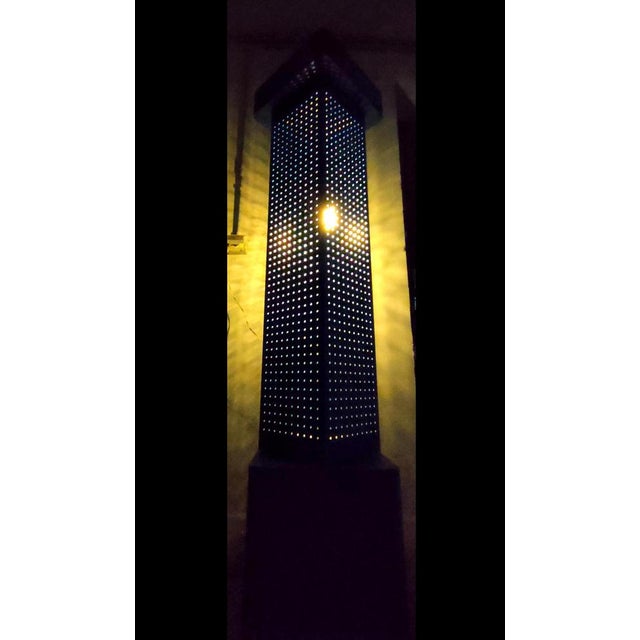 Rare and particular original floor lamp of the 80s, made of pierced metal with solid wood base. The central part is swivel...