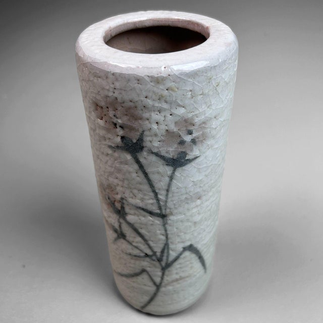 This elegant cylinder vase is a stunning example of traditional Shino pottery, known for its warm, organic shapes and...