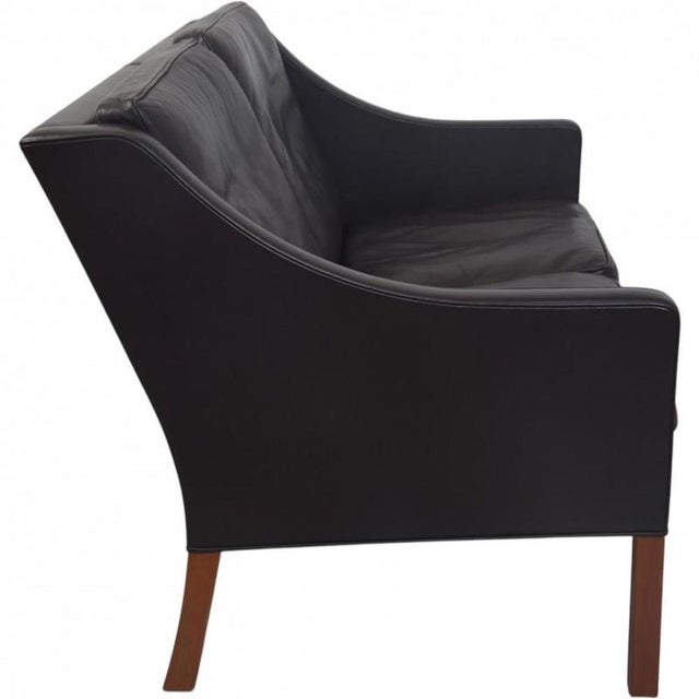 Børge Mogensen 2208 2.seater sofa upholstered in black leather and with legs of mahogany. The sofa is from the 1990s and...