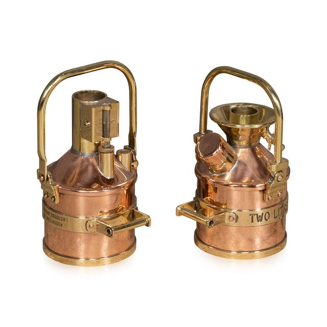 Vintage 20th Century pair of polished brass and copper petrol measuring canisters, once used at the pump by the London...