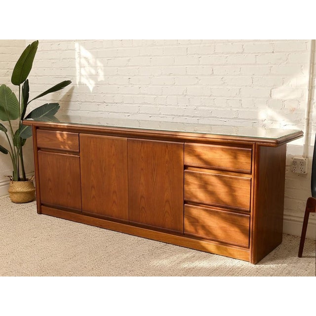 A substantial vintage mid-century modern credenza featuring a warm walnut finish, generous storage, and a beautifully...