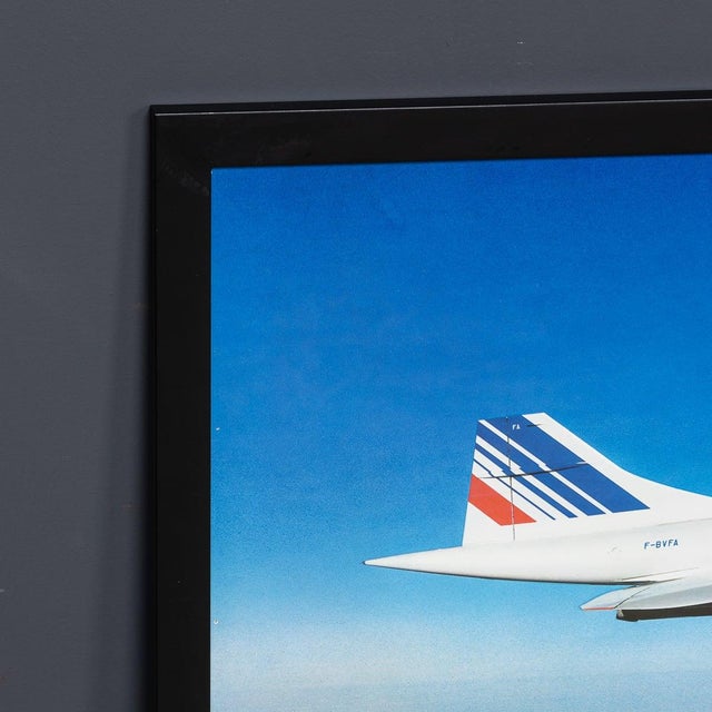 A superb vintage 20th Century framed poster of an Air France Concorde in flight over water. Framed in a sleek, black frame...