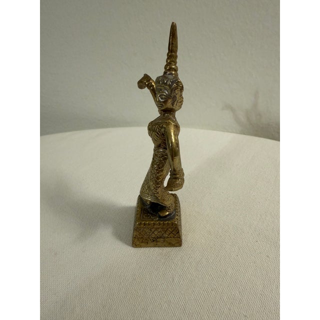 Elegant vintage brass figurine depicting a traditional Southeast Asian dancer in classic Apsara style, often associated...