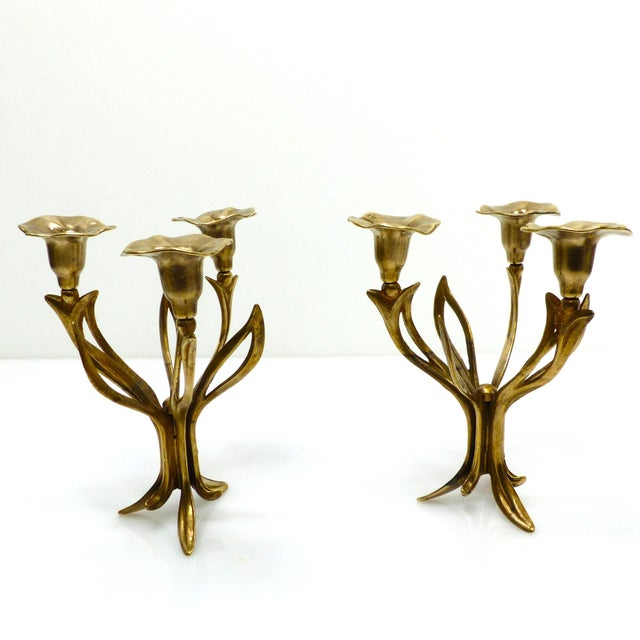 Pair of three-light tripod candlesticks in gilt brass, with organic floral decoration inspired by the arum lily, European...