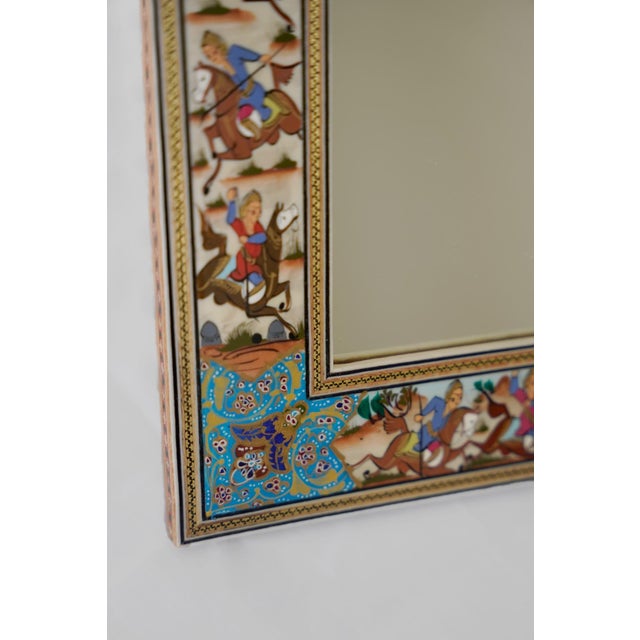 This hand-painted decorative mirror showcases a polo scene inspired by the rich tradition of Persian miniature painting....