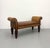 A substantial Pulaski upholstered bench featuring elegant neoclassical scroll arms, richly carved wood accents, and turned...