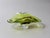 An impressive Murano art glass bowl distinguished by its luminous apple-green coloration, warm brown accent, and flowing...