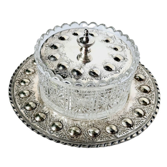 Antique silver-plated and glass butter dish with silver-plated lid and tray. Dish and lid have frieze has raised circular...