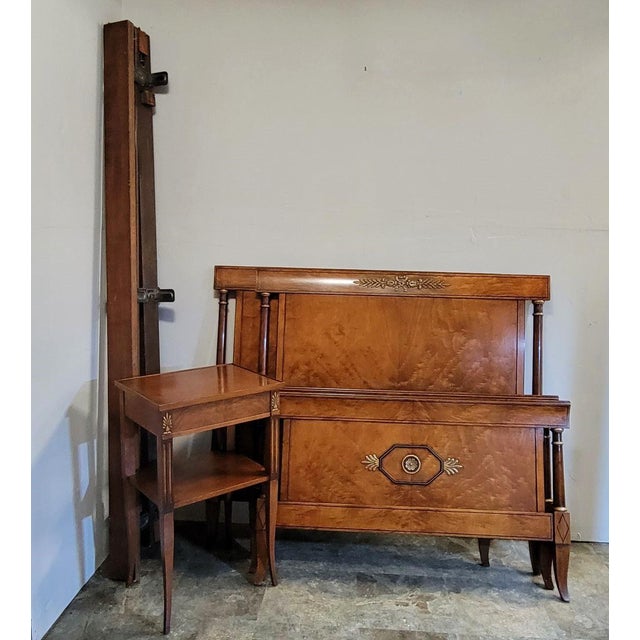A pair of Italian Louis XVI–style twin beds with matching nightstand, crafted in richly figured flame birch veneers with...