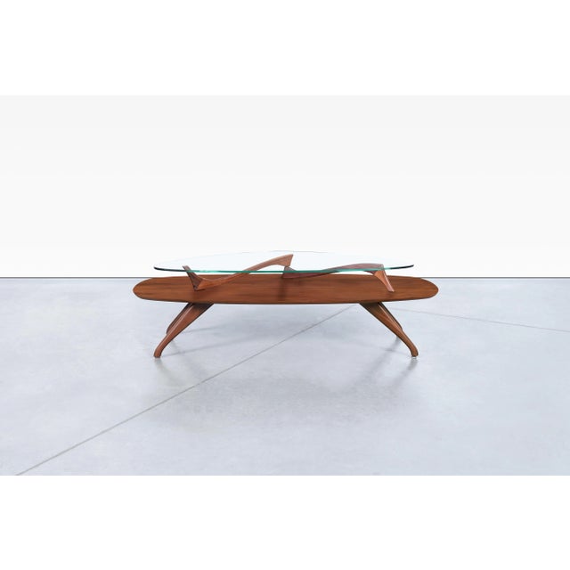Vintage sculptural walnut coffee table, United States, circa 1960s. Defined by its flowing silhouette and organic lines,...