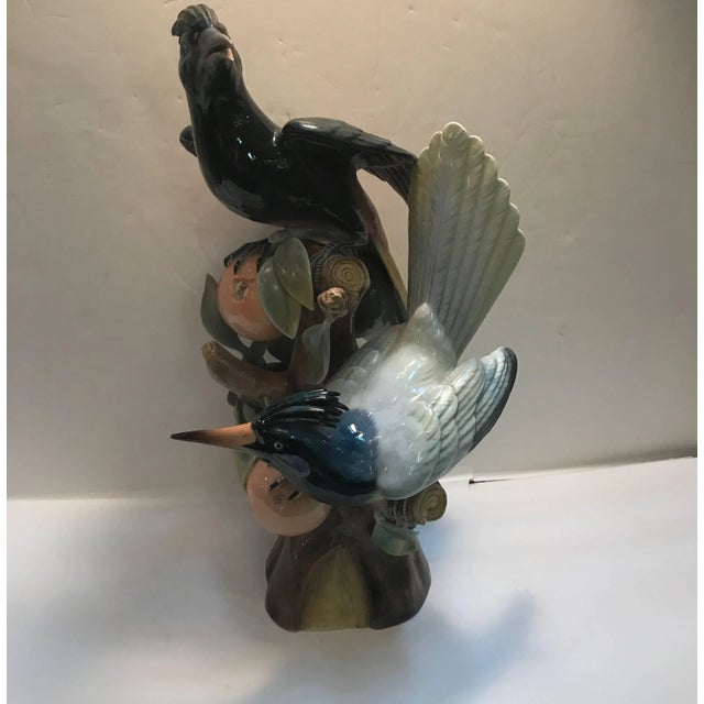 A Portuguese porcelain figure of a male and female Hoopoe bird. The birds resting and feeding on branches of pomegranate...