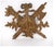 An elaborately carved gilt armorial crest or wall trophy with two a central scrolled shield, ribbon bow with a rosette,...